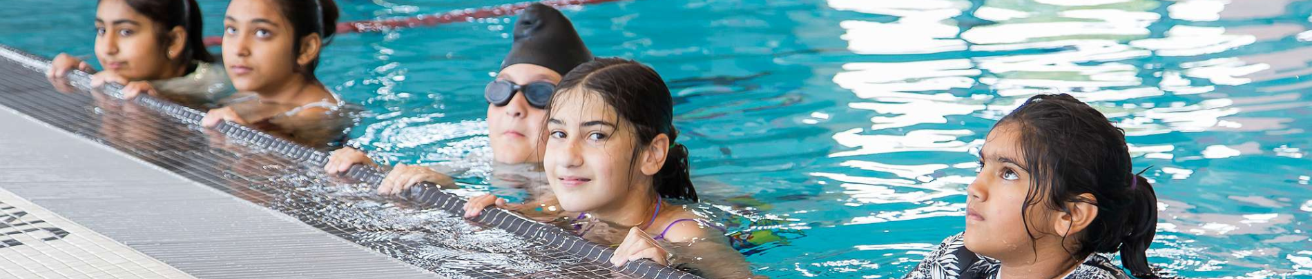 Group of girls holding the edge of the pool